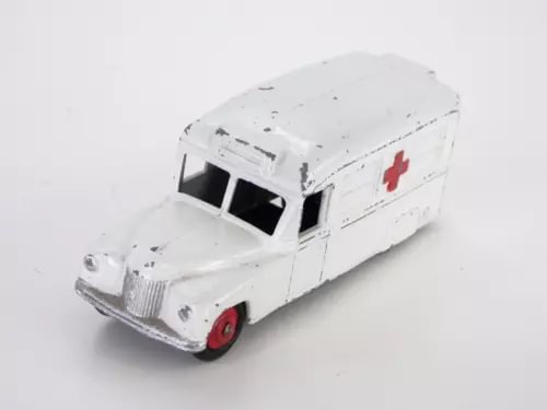 Vintage diecast ambulance toy van, white body with red cross, front/side view.