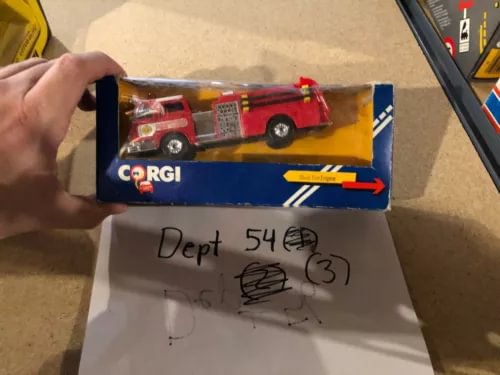 Red diecast fire engine toy with Corgi branding in blue retail box