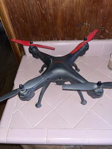 Dark gray quadcopter drone with red propellers and four landing legs