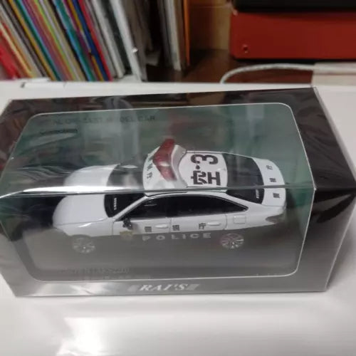 White police diecast toy car with black roof in clear display box