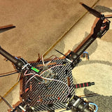 Carbon fiber quadcopter drone with exposed circuit board and propellers