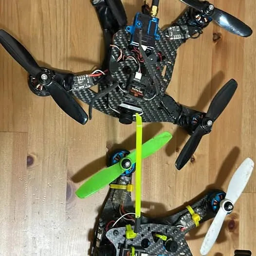 FPV drone with black carbon-fiber frame and neon green propellers, quadcopter