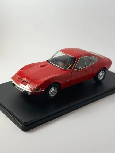 Red 1/24 diecast sports car model, front 3/4 view with chrome grille