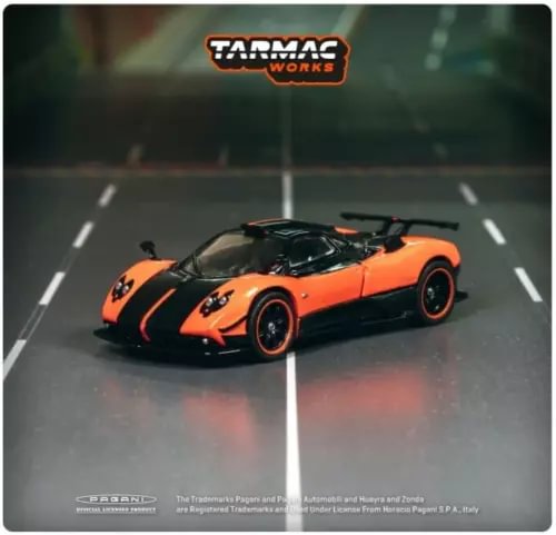 Diecast model car, orange and black with racing stripes, front three-quarter view