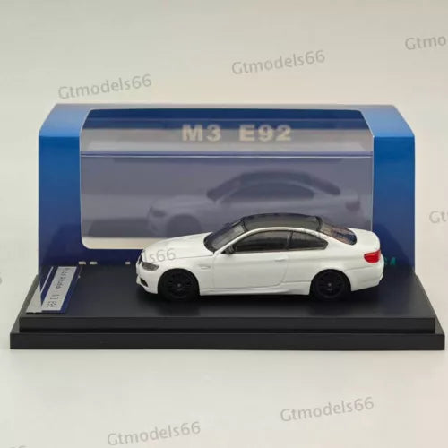 White 1:64 BMW M3 E92 diecast model car on black display base, in box