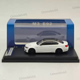 White 1:64 BMW M3 E92 diecast model car on black display base, in box