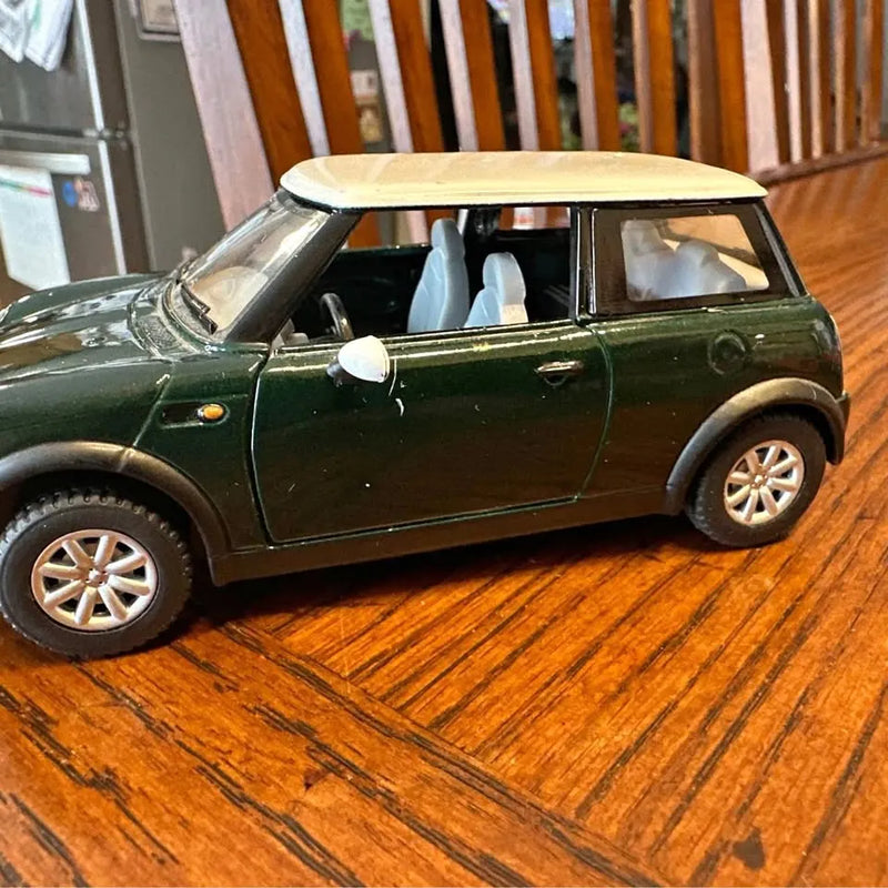 Green metallic diecast mini car model toy, side view with white roof