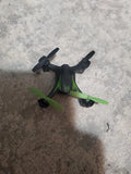 Green and black nano quadcopter drone with four propellers, compact indoor model