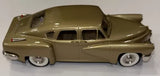 Olive-gold vintage die-cast torpedo car model with whitewall tires and chrome bumper