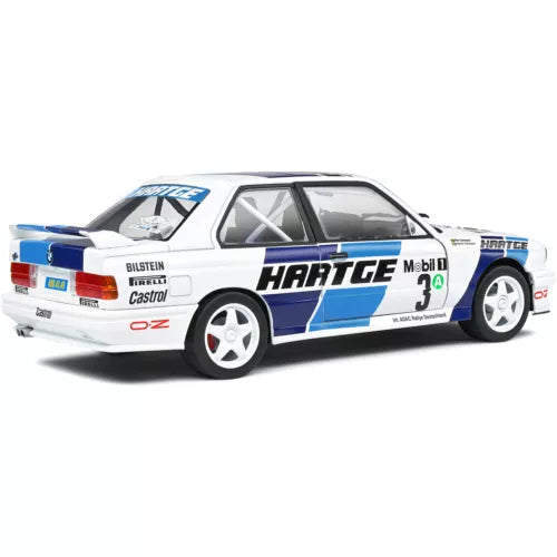 1:18 diecast race car model, white with blue and black Hartge decals, side view.