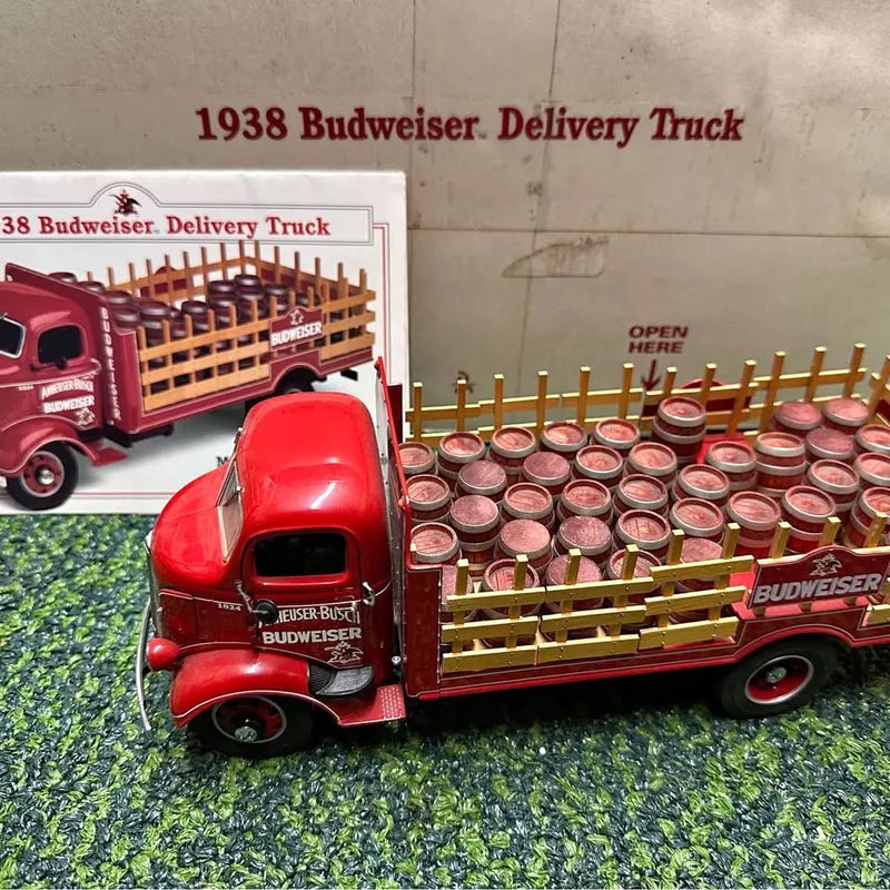 Red diecast delivery truck with wooden rack and many Budweiser beer barrels