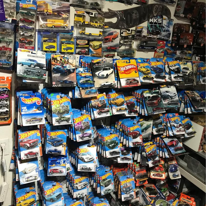Hot Wheels diecast toy cars in blue blister packs on a retail shelf