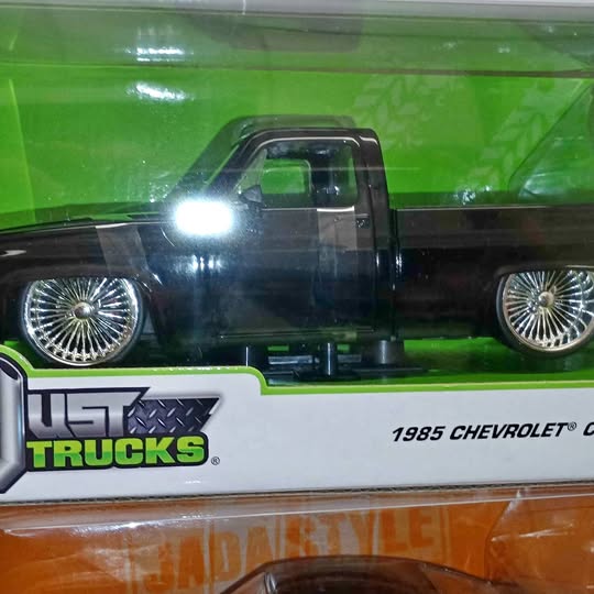 Diecast pickup truck in green and black with chrome wheels, front view
