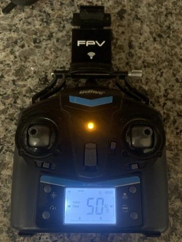 Black FPV remote radio controller with screen displaying 50% and antenna icon