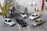Five 1:64 Mercedes E55 diecast model cars in silver, black, white, and beige