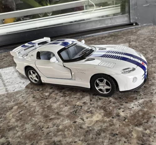 White diecast sports car model with blue racing stripes and hardtop roof
