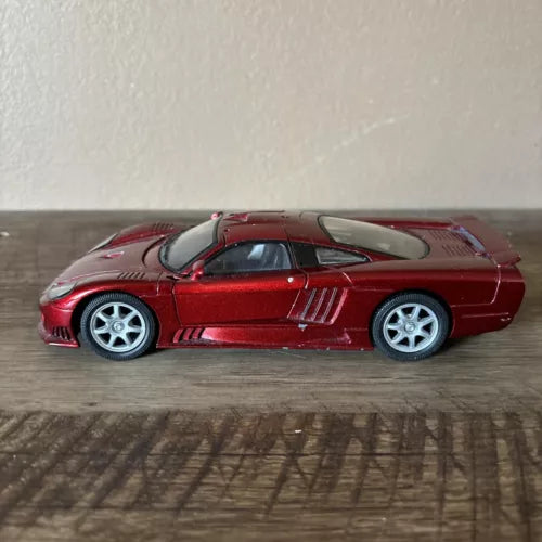 Red diecast sports car with white wheels, side view