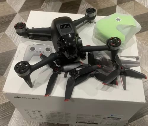 Black FPV drone with four propellers, compact body and front camera pod