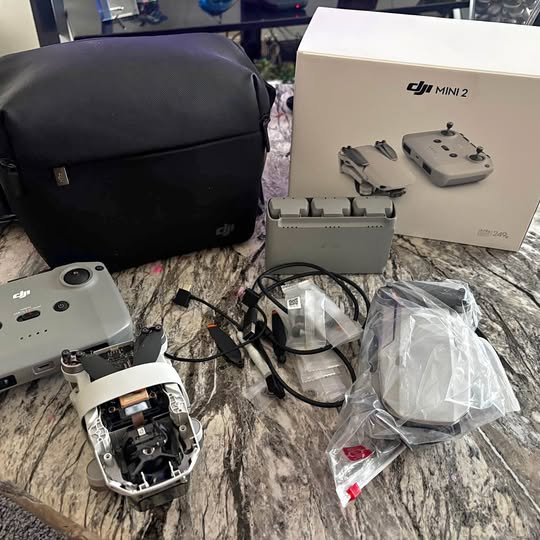 DJI Mini 2 drone and accessories set with controller, cables, and carrying bag
