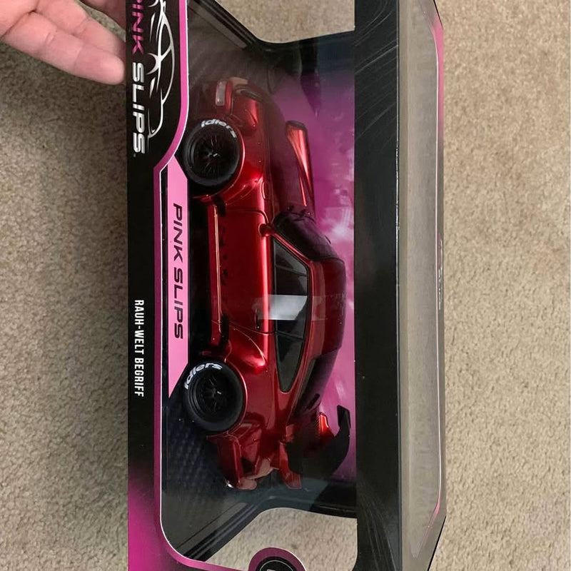 Red diecast sports car model in retail box, black wheels, front view