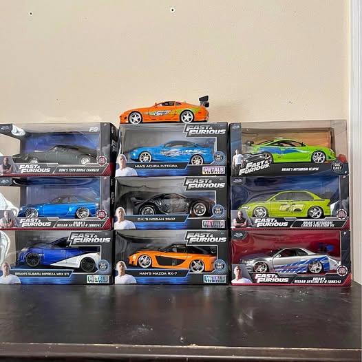 Diecast car set in retail boxes, featuring blue, orange, green, and gray cars