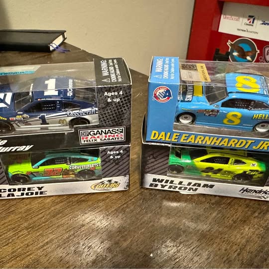 Boxed diecast race cars with blue and green models on packaging, age 4+