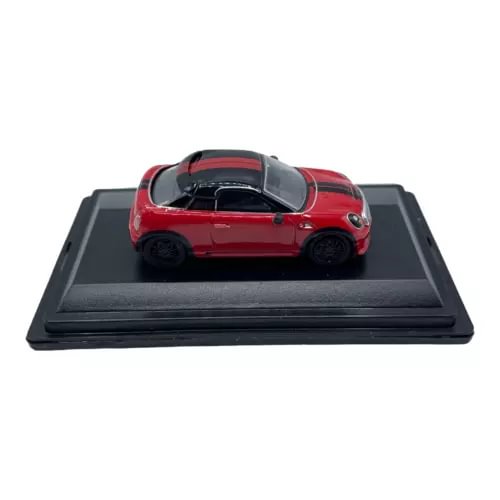 Red diecast coupe car model with black roof, on black display base (1:76 scale).