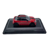 Red diecast coupe car model with black roof, on black display base (1:76 scale).