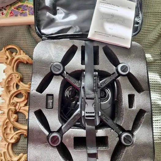 Quadcopter drone in open carrying case with four black propellers visible