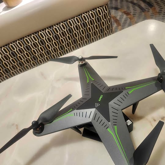 NV Drone with four propellers, dark gray body and neon green accents
