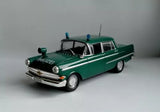 Green vintage diecast police car model with white stripe and roof light, 1:43 scale