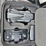 Foldable drone with remote controller in a gray carrying case