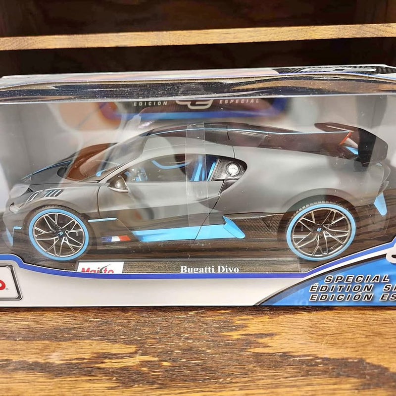Diecast model car in clear box, silver-gray with blue side accents and wheels