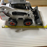 Gray diecast skid-steer loader model with front bucket and black wheels