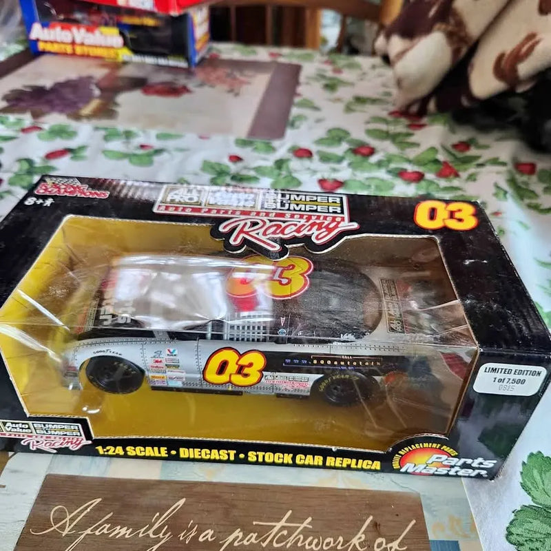 Diecast stock car replica in retail box, yellow '03' race car, 1:24 scale