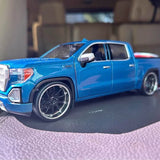 Blue diecast pickup truck model with chrome grille, front bumper, and spoked wheels