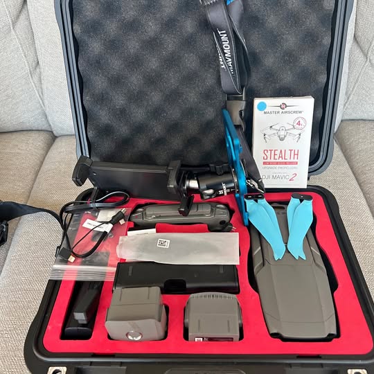 Foldable drone accessory kit in hard case with drone body, batteries, and prop guards