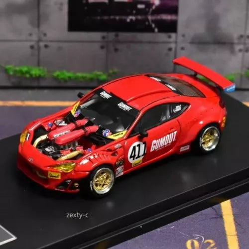 Red diecast racing car model with #411 decals, black accents, and gold wheels