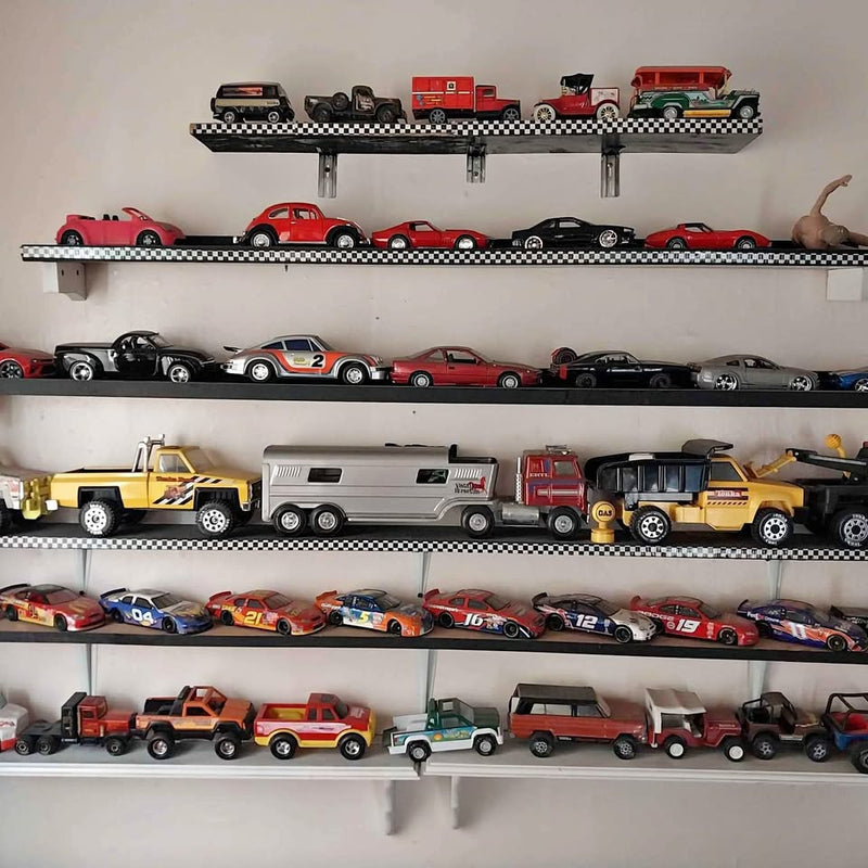 Diecast toy car set on wall shelves, assorted red, black, and yellow vehicles