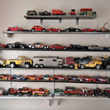 Diecast toy car set on wall shelves, assorted red, black, and yellow vehicles