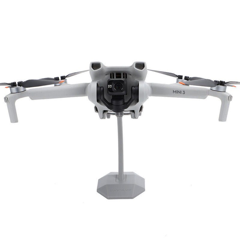 Plastic desktop drone stand with center pole and gray base holding a drone