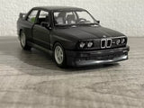 Matte black die-cast car model, front three-quarter view with detailed grille and lights