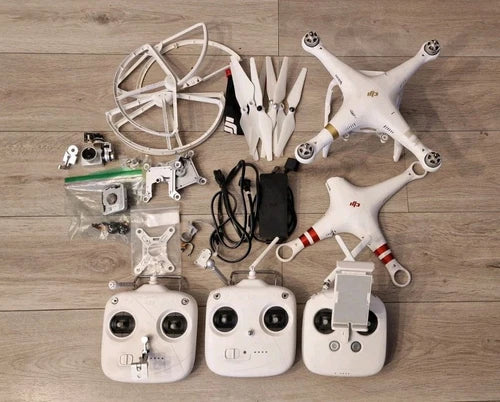 White DJI Phantom 3 Professional drone parts with controller transmitters