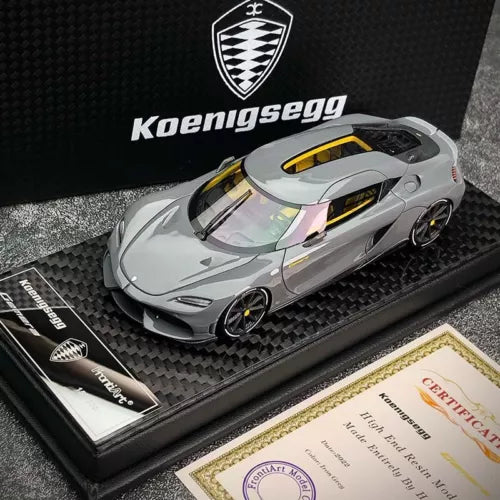 Iron grey 1:43 diecast model car with yellow windshield accents on display base