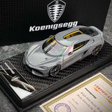 Iron grey 1:43 diecast model car with yellow windshield accents on display base