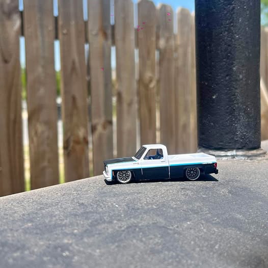 Diecast pickup truck toy, white and light blue with black wheels, front 3/4 view