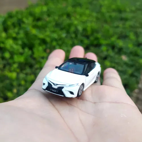 White diecast model car with black detailing, small front view in hand
