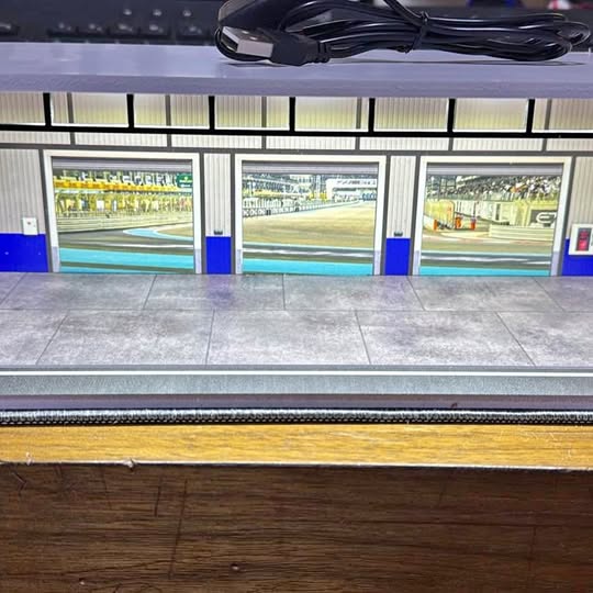 Diecast display garage with three storefront windows and blue posts