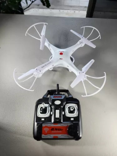 White RC quadcopter drone with four propellers and black remote controller