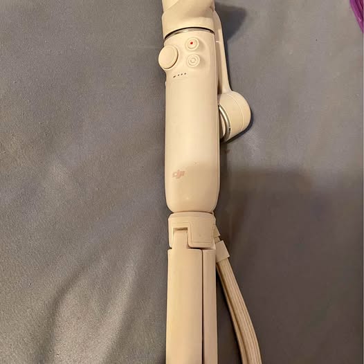 Dji OM 5 handheld gimbal stabilizer with white handle and mounted control module
